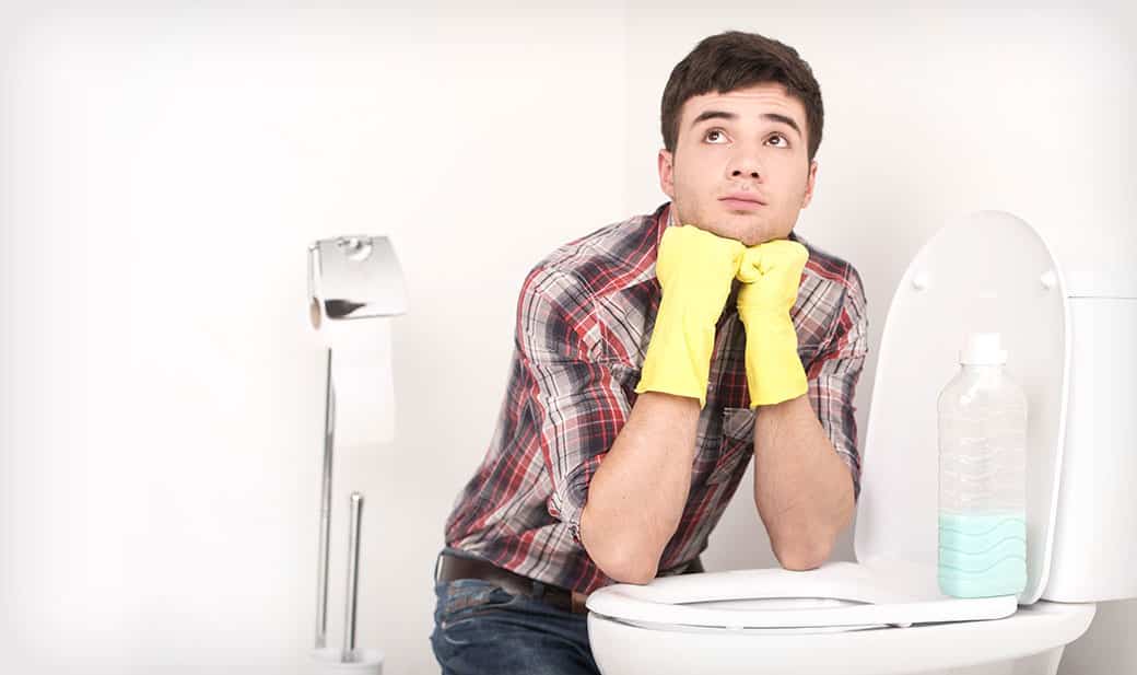 Photo of man cleaning a toilet.