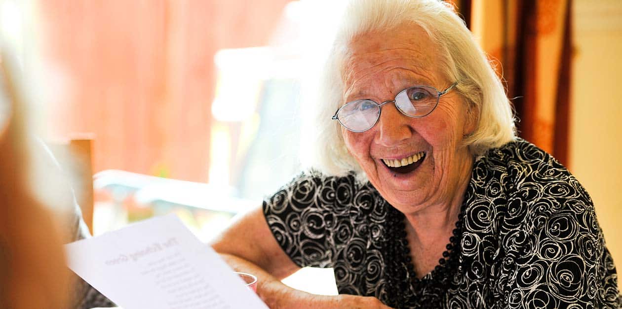 Photo of retirement village resident reading a page.